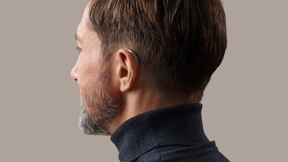 Image shows a man wearing the Oticon Opn S Hearing Aid
