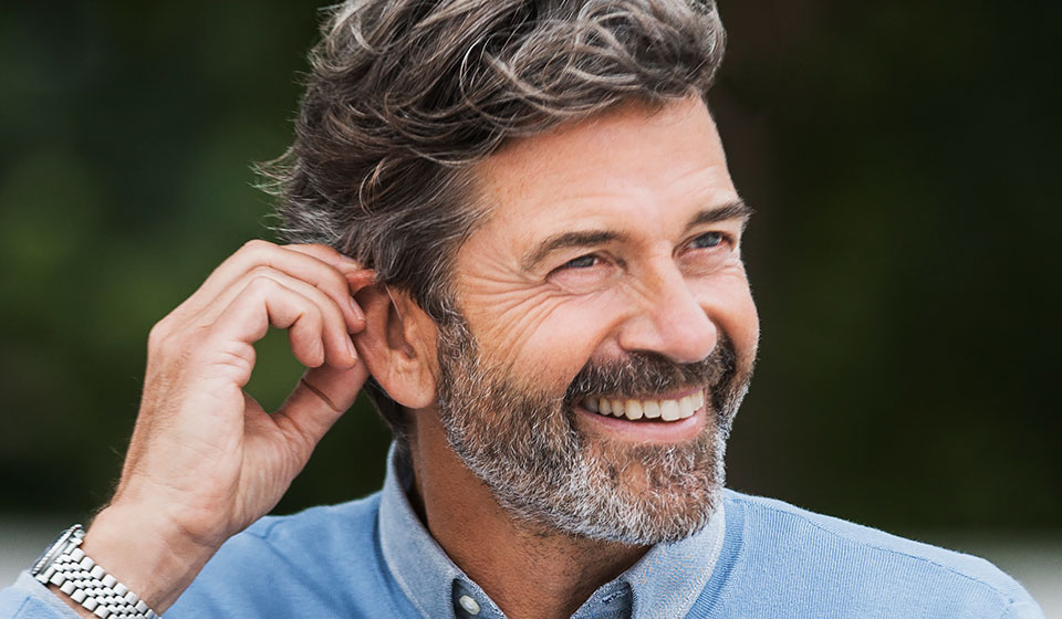 Image shows man wearing Oticon Opn hearing aids