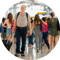 Image shows an older man who cannot hear the tannoy at an airport due to age related hearing loss