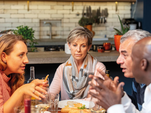 Woman is suffering from hearing loss at a family dinner