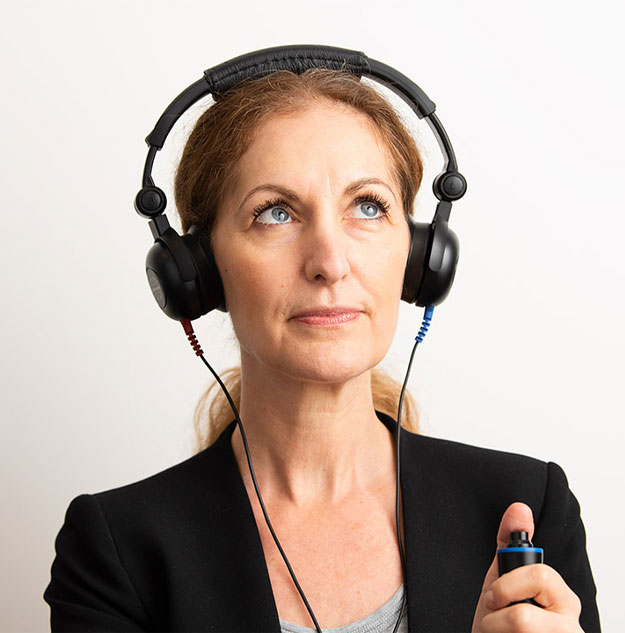 Image shows a woman taking a hearing test