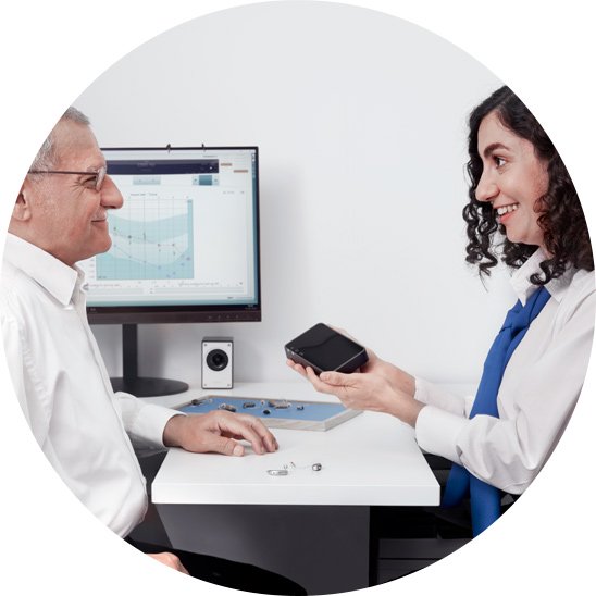 Image shows an audiologist helping a customer find the right hearing aid for them