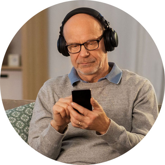 Image shows a man taking an online hearing test at home on his smartphone