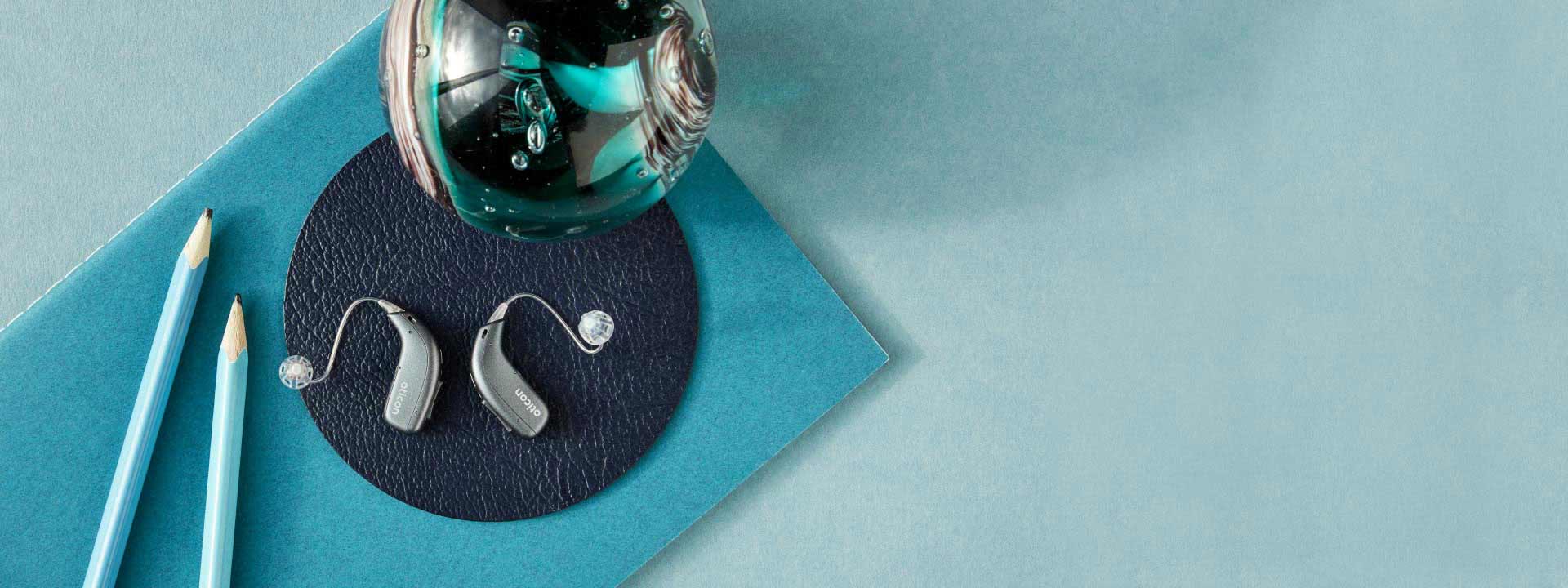 Η εικόνα δείχνει δύο ακουστικά βαρηκοΐας τοποθετημένα σε μπλε φόντο