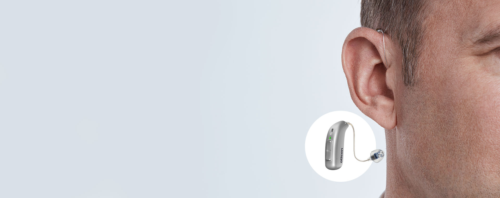 Image shows a hearing aid placed behind the ear
