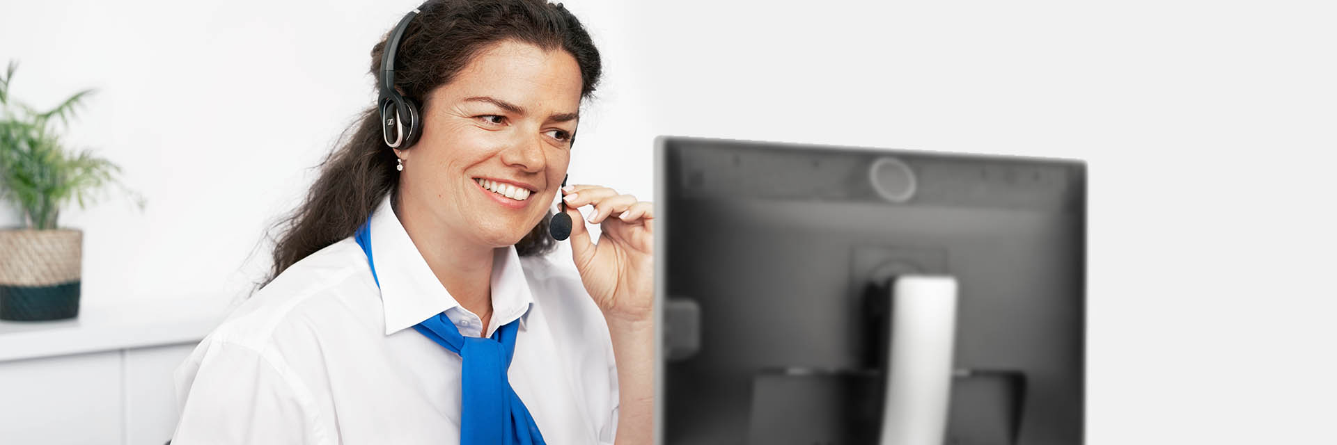 Immagine di una donna in un call center che rispondere a una chiamata con le cuffie accese