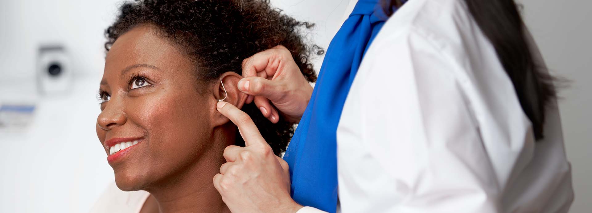 Billede viser en kvinde med et høreapparat bag øret