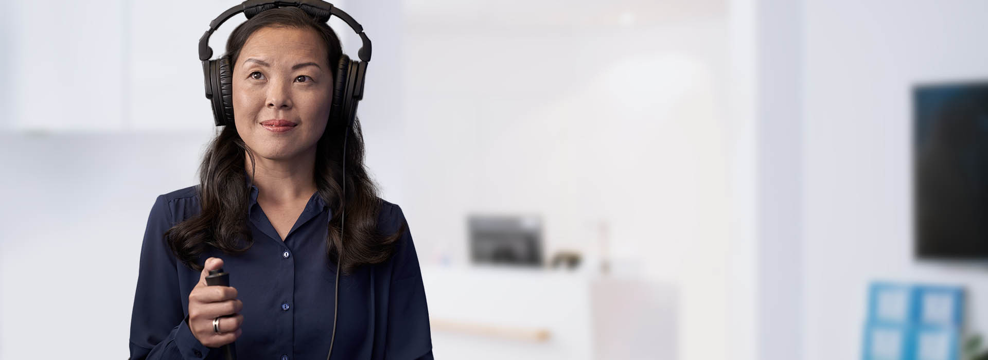 La imagen muestra una mujer con auriculares realizando el test auditivo online