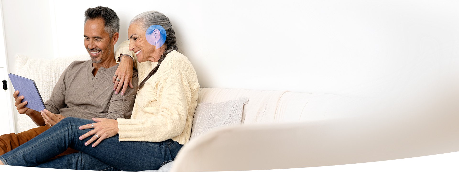 Image shows woman in with headphones on conducting an online hearing test