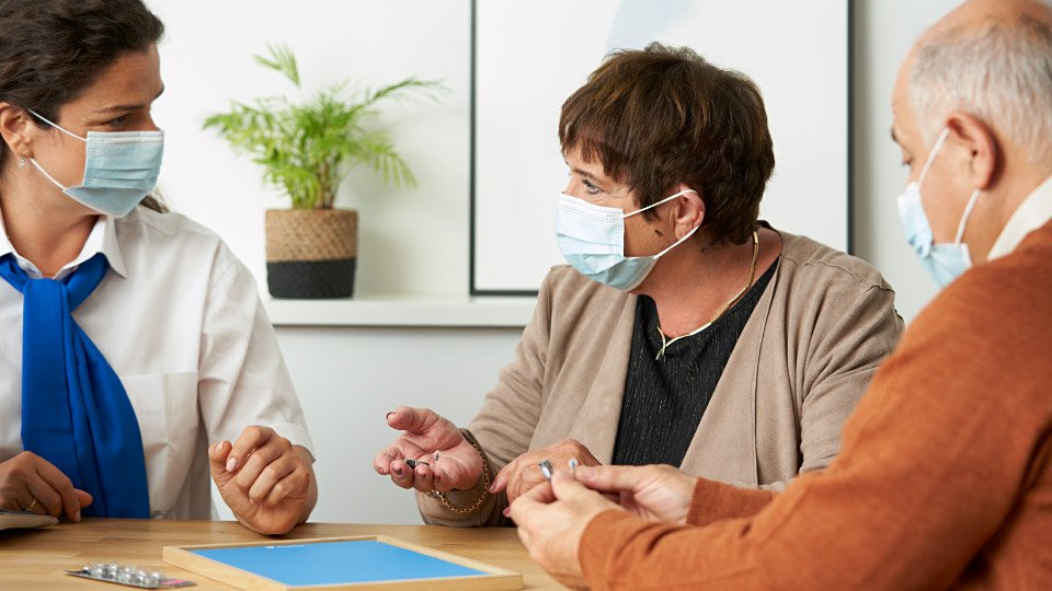 Image show three people with facemask talking