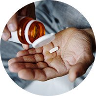 Image shows hand holding some medication