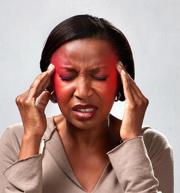 L’image montre une femme avec une rougeur dans la tête qui met ses mains sur son front