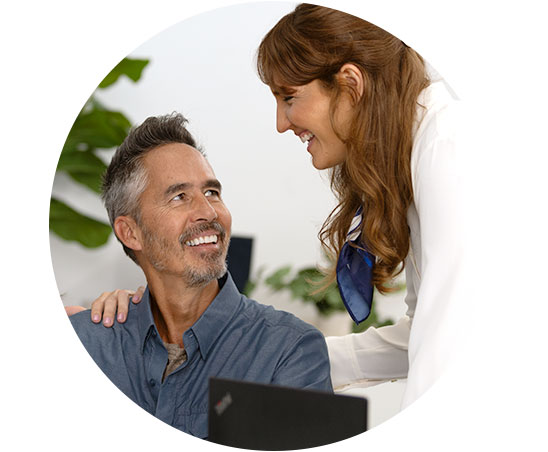 Image shows man talking to audiologist in front of a screen showing an audiogram