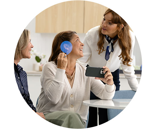 Image shows an audiologist talking with a woman about her hearing