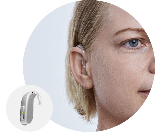 Imagem mostra mulher a usar um aparelho auditivo atrás da orelha