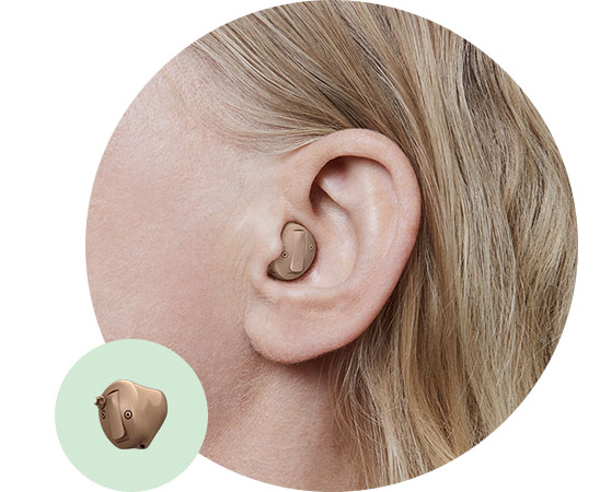 La imagen muestra un audífono intracanal en el oído de una mujer