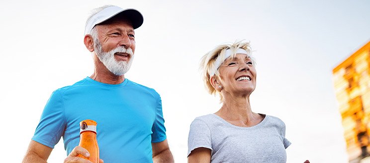 Image shows elderly couple running