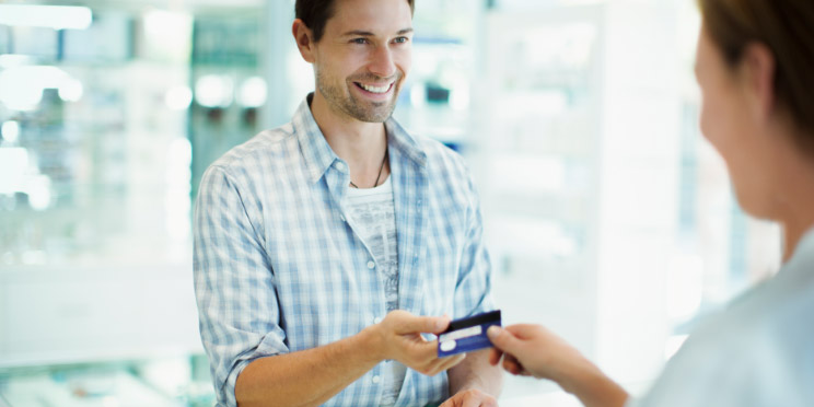 L'image montre un homme avec une carte bancaire