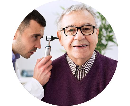 L’image montre un audioprothésiste examinant l’oreille d’un homme dont la perte auditive a été causée par le vieillissement