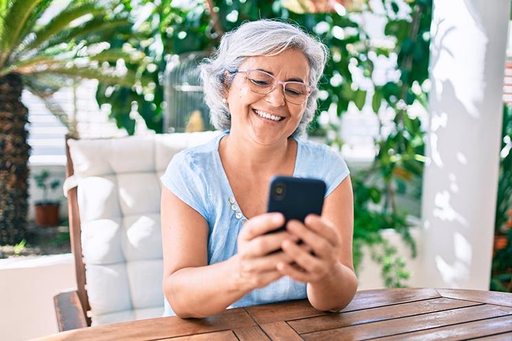 L'immagine mostra una donna che guarda il suo cellulare