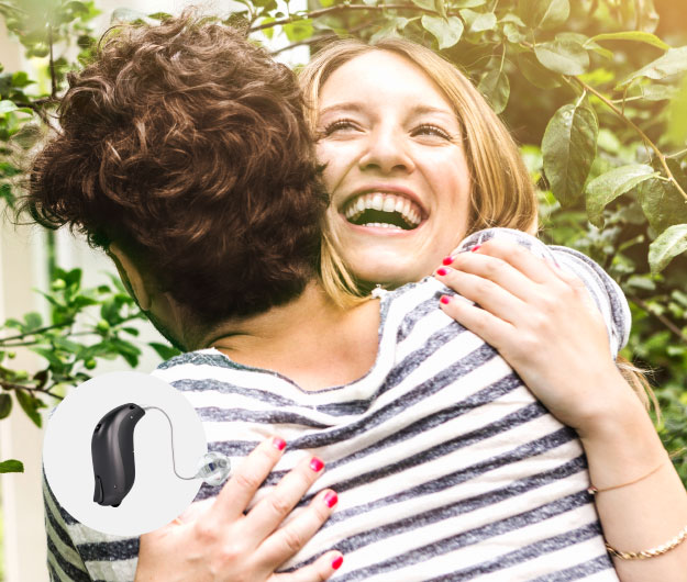Afbeelding van twee personen die knuffelen met Bernafon Viron hoorapparaat op voorgrond